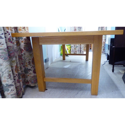 28 - A modern light oak refectory table, raised on square legs  30