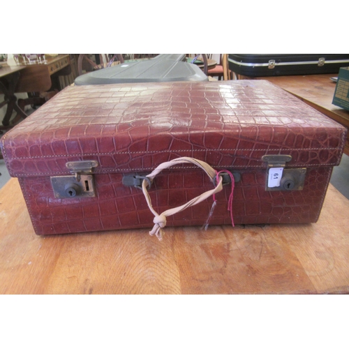 61 - A vintage crocodile skin vanity case with brass clasps, enclosing a part fitted interior  7.5