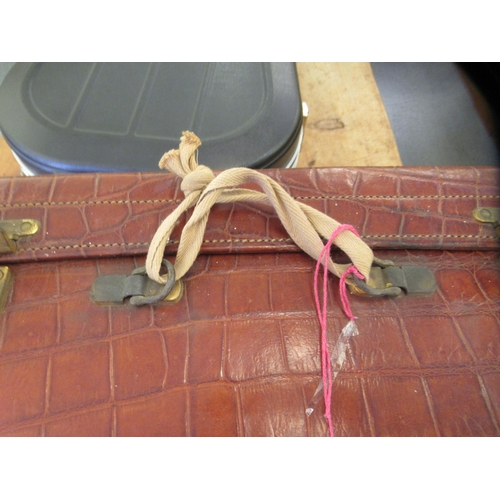 61 - A vintage crocodile skin vanity case with brass clasps, enclosing a part fitted interior  7.5