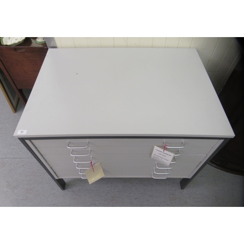 63 - A modern grey painted laminate six drawer plan desk, raised on rectangular legs  33