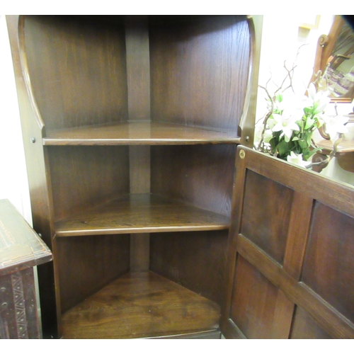 268 - An Ercol dark oak corner unit with three open shelves, over a base drawer, on a plinth  72