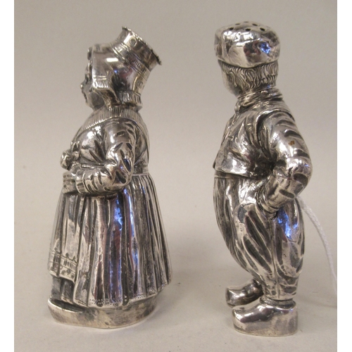 1 - A pair of Continental silver novelty pepper pots, respectively fashioned as a standing Dutch boy and... 