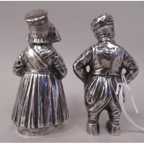 1 - A pair of Continental silver novelty pepper pots, respectively fashioned as a standing Dutch boy and... 