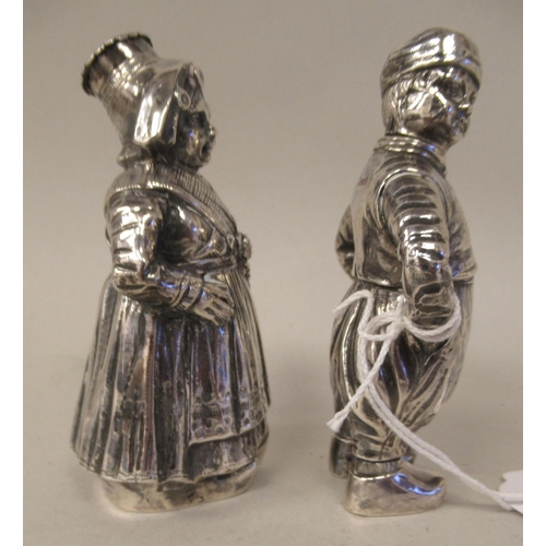 1 - A pair of Continental silver novelty pepper pots, respectively fashioned as a standing Dutch boy and... 