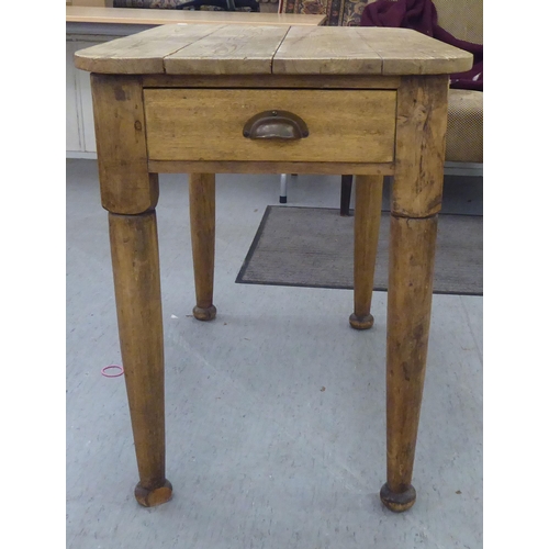 111 - A late 19th/early 20thC rustically constructed pine kitchen table, the planked top with round corner... 