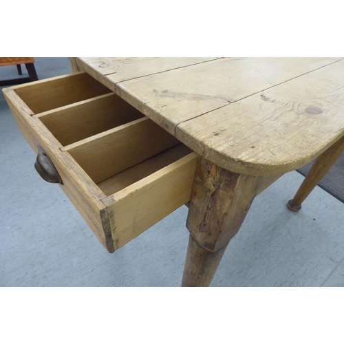 111 - A late 19th/early 20thC rustically constructed pine kitchen table, the planked top with round corner... 