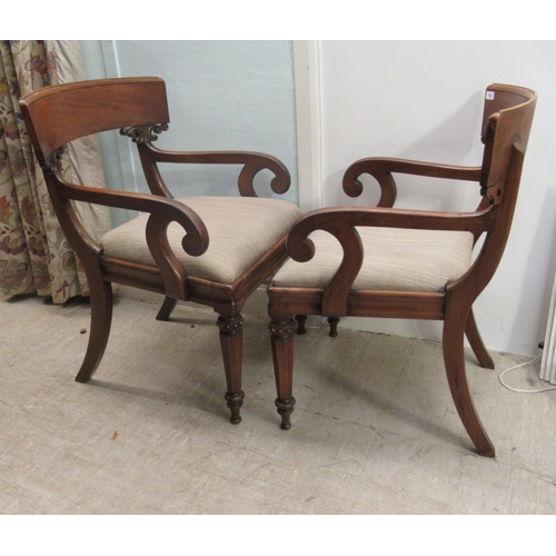 122 - A pair of William IV mahogany framed bar back open arm chairs, the later fabric upholstered drop-in ... 