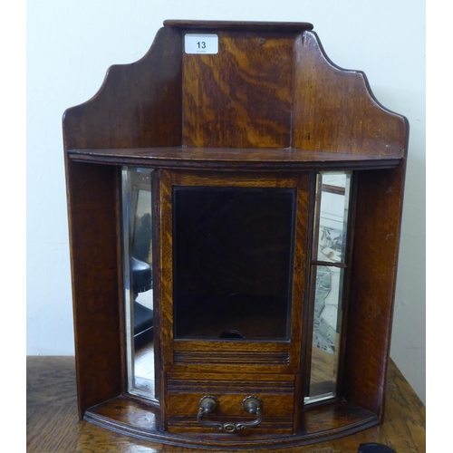 13 - A 1920s oak hanging smokers corner cabinet with a lockable, bevelled glazed panelled door and a base... 