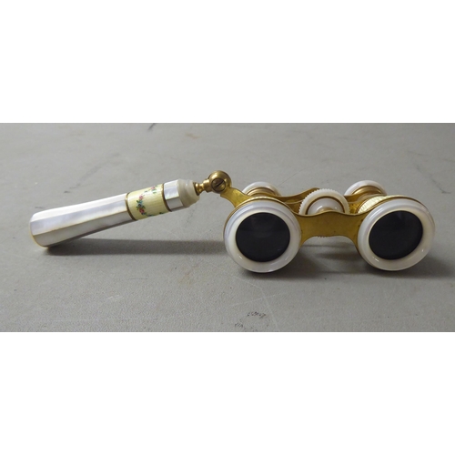 140 - A pair of lacquered gilt metal mother-of-pearl and painted enamel opera glasses, on an offset handle... 