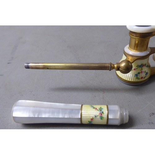 140 - A pair of lacquered gilt metal mother-of-pearl and painted enamel opera glasses, on an offset handle... 