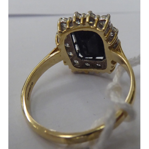 150 - A 9ct gold ring, set with an elevated sapphire, surrounded by cubic zirconias