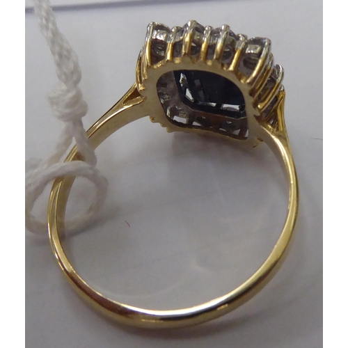 150 - A 9ct gold ring, set with an elevated sapphire, surrounded by cubic zirconias