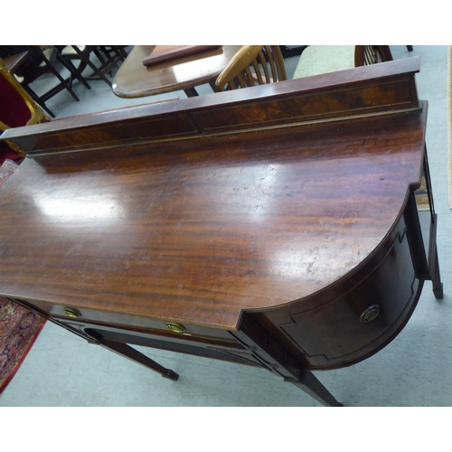 151 - An Edwardian mahogany breakfront sideboard with two drawers and two doors, raised on square, tapered... 