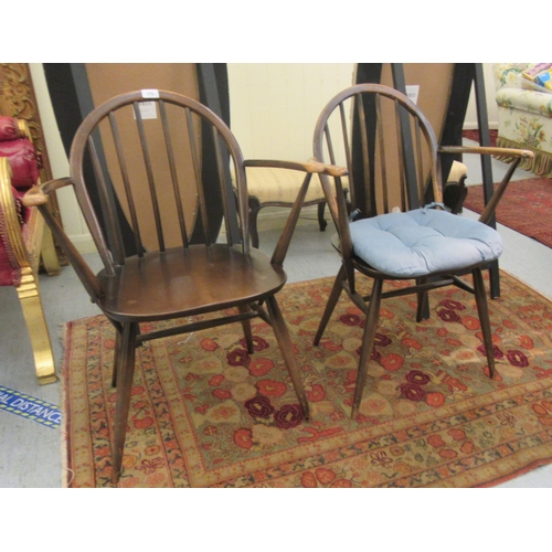 176 - A pair of Ercol stained beech and elm framed hoop and stick back, open arm chairs, the solid seats r... 