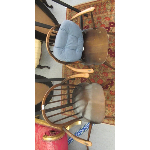 176 - A pair of Ercol stained beech and elm framed hoop and stick back, open arm chairs, the solid seats r... 