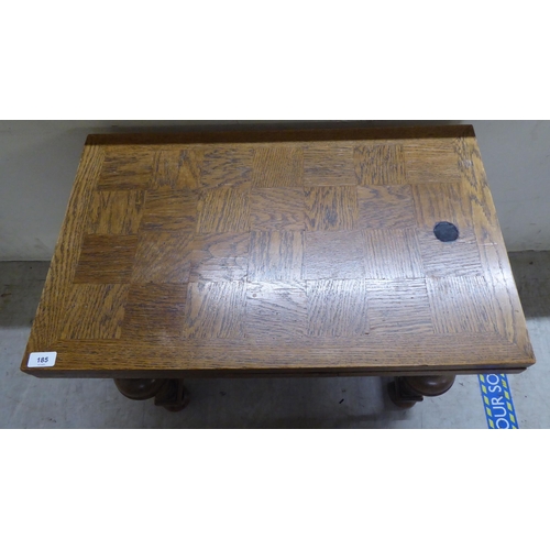 185 - A mid 20thC oak draw leaf occasional table, raised on turned, block supports, united by a stretcher&... 