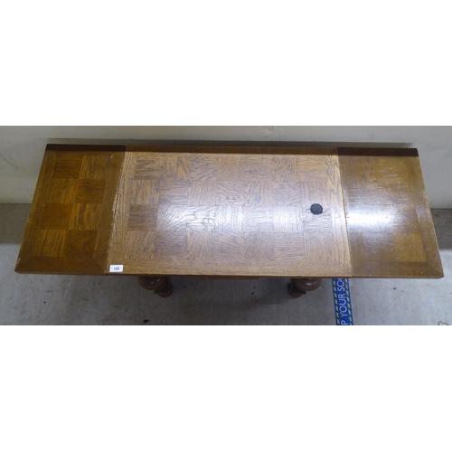 185 - A mid 20thC oak draw leaf occasional table, raised on turned, block supports, united by a stretcher&... 