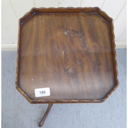 186 - A 19thC style mahogany wine table with a galleried tray-top and later candle slide, over a ring turn... 