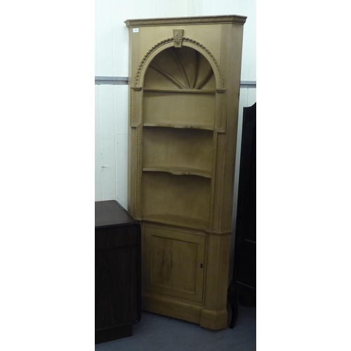 193 - A modern two tone pine, one piece corner cabinet with a concave two tier display, over a panelled do... 