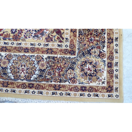 198 - A Persian inspired machine made rug, profusely decorated with floral designs, on a multi-coloured gr... 