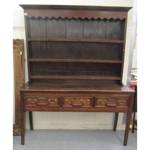 200 - A George III stained oak dresser, the superstructure with three open plate racks, over three inline ... 