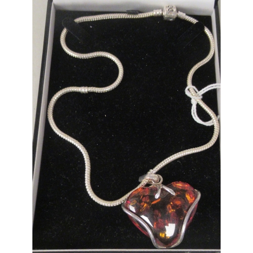 211 - A Pandora white metal necklace with a heart shaped, amber coloured stone