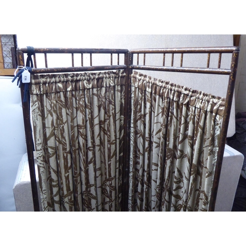 236 - A 20thC painted bamboo effect framed two-fold dressing room screen with fabric curtains  66