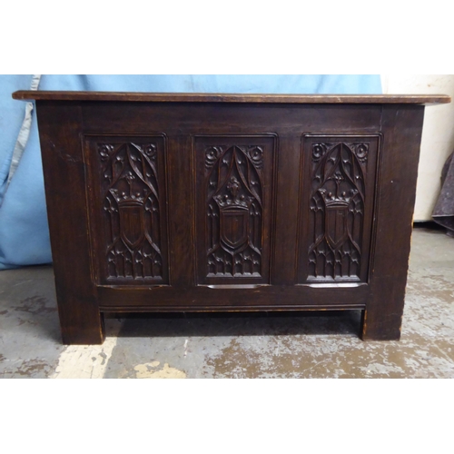 244 - A 1930s Gothic inspired stained oak blanket chest with straight sides and a hinged lid, over a tri-p... 