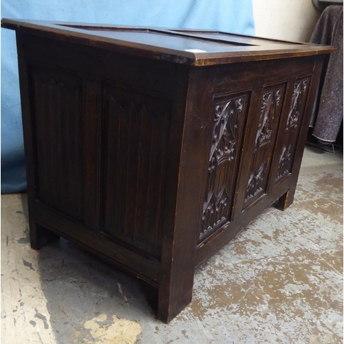 244 - A 1930s Gothic inspired stained oak blanket chest with straight sides and a hinged lid, over a tri-p... 