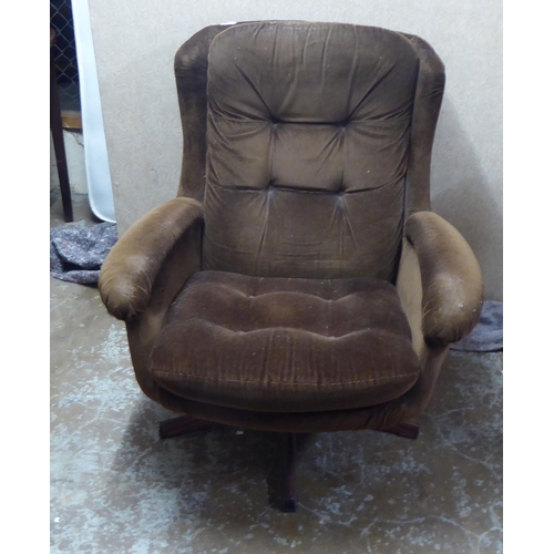 252 - A late 1960s/early 1970s brown fabric upholstered chair, raised and rotating on a faux rosewood base