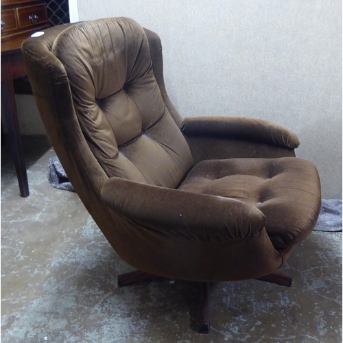 252 - A late 1960s/early 1970s brown fabric upholstered chair, raised and rotating on a faux rosewood base