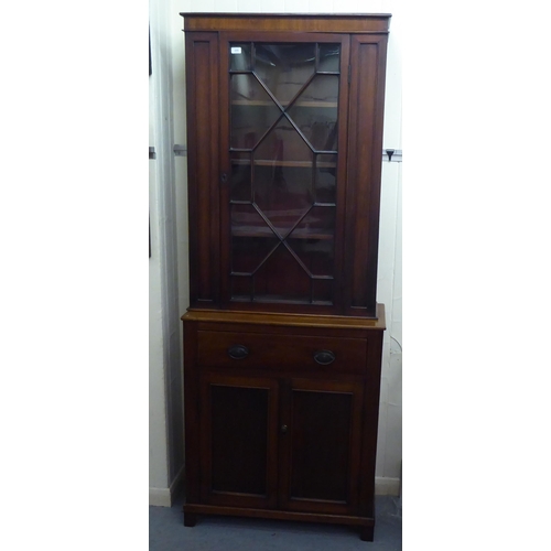 255 - A late Victorian mahogany two section display cabinet with an astragal glazed door, over a drawer an... 