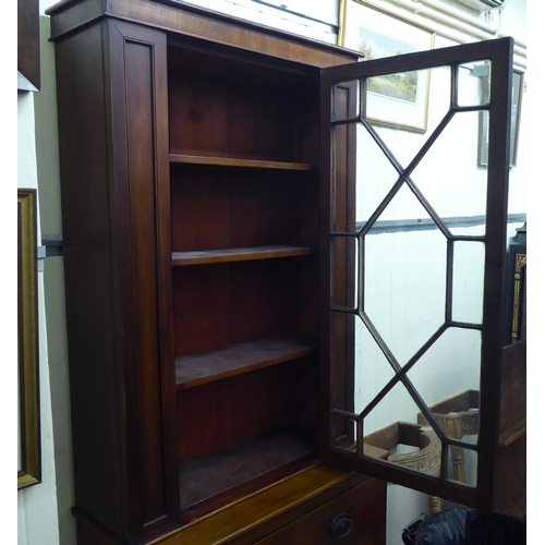 255 - A late Victorian mahogany two section display cabinet with an astragal glazed door, over a drawer an... 