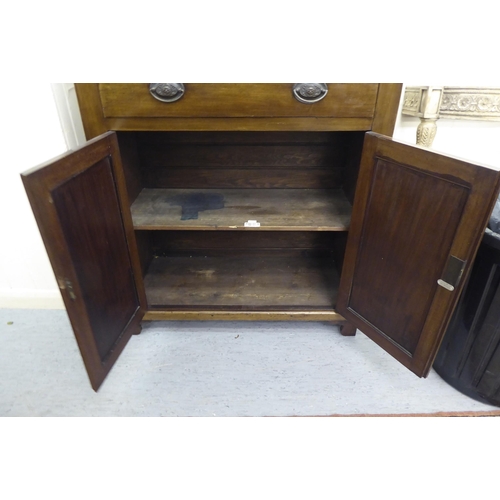 255 - A late Victorian mahogany two section display cabinet with an astragal glazed door, over a drawer an... 