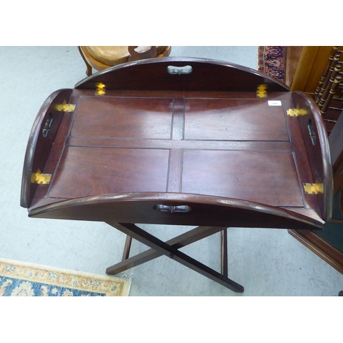 289 - An early 20thC mahogany butler's tray with cut-out handles to the four folding flaps  30