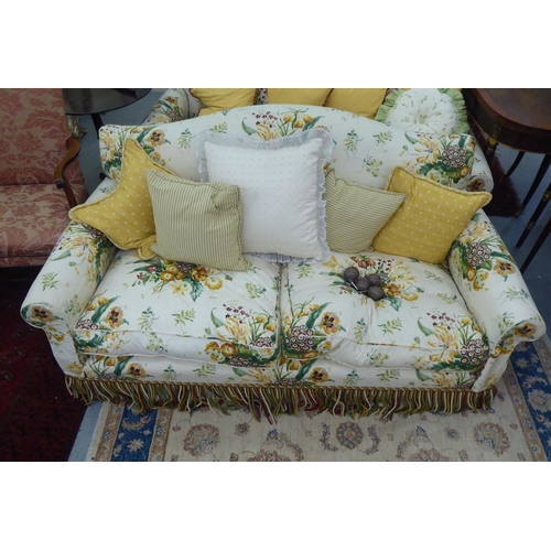 300 - A Peter Dudgeon two person cottage design settee with scrolled arms, upholstered in floral patterned... 