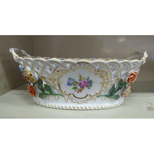 308 - A Dresden porcelain oval, twin handled basket, decorated with painted and encrusted flora, highlight... 