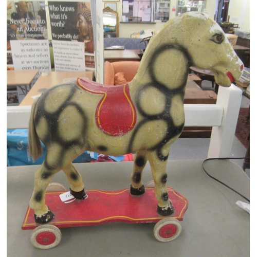 312 - A vintage painted pull-along toy dappled horse, on wheels  18