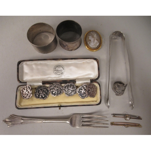 32 - Items of personal ornament and silver: to include a pair of 19thC bright-cut engraved sugar tongs; a... 