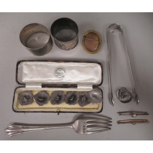 32 - Items of personal ornament and silver: to include a pair of 19thC bright-cut engraved sugar tongs; a... 