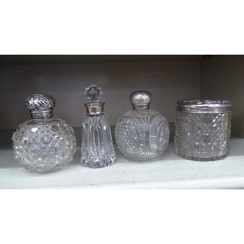 322 - Four dissimilar silver mounted dressing table jars  mixed marks