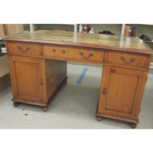 340 - A mid Victorian mahogany, twin pedestal desk, the top set with a tooled and gilded green hide scribe... 