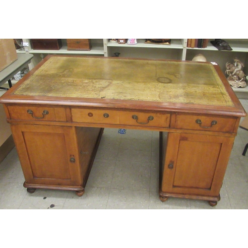 340 - A mid Victorian mahogany, twin pedestal desk, the top set with a tooled and gilded green hide scribe... 