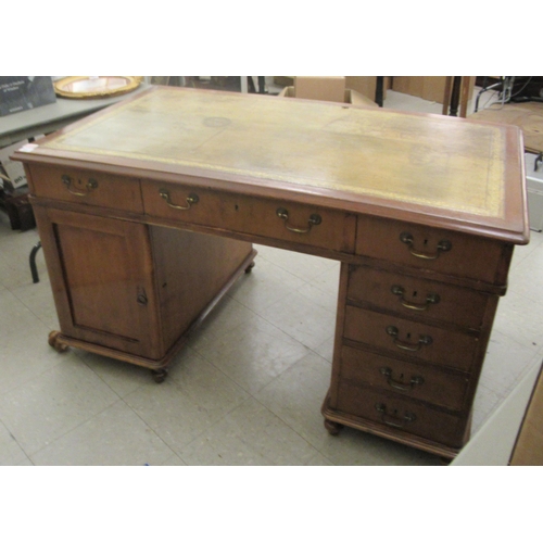 340 - A mid Victorian mahogany, twin pedestal desk, the top set with a tooled and gilded green hide scribe... 