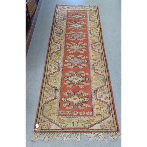 342 - A Turkish woollen runner, decorated in colours with repeating stylised designs  105