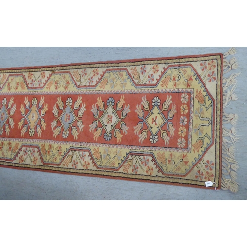 342 - A Turkish woollen runner, decorated in colours with repeating stylised designs  105