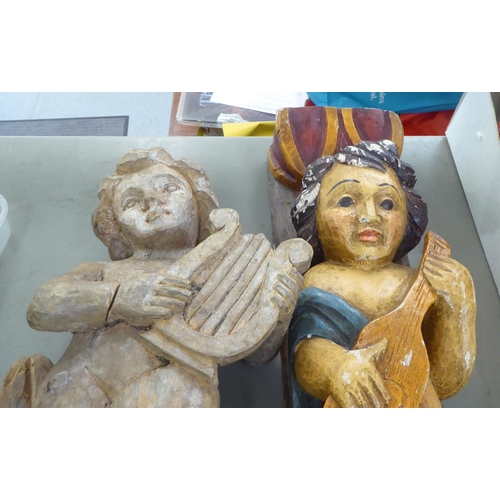 353 - Two dissimilar carved wooden cherubic figures, on plinths  21