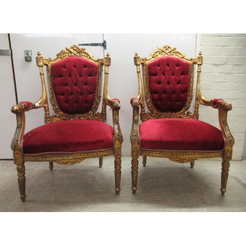 360 - A pair of late Victorian style gilded, moulded and carved salon chairs with open arms and part butto... 