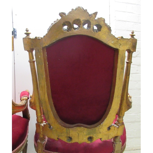 360 - A pair of late Victorian style gilded, moulded and carved salon chairs with open arms and part butto... 