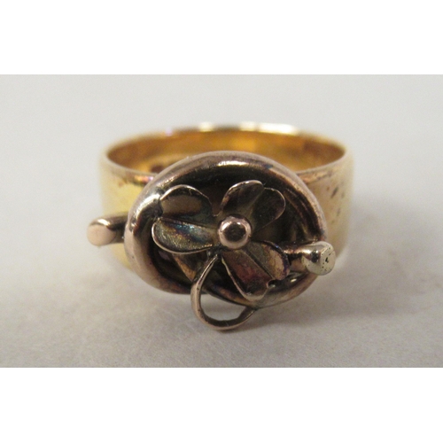 38 - An 18ct gold band ring, surmounted by a flowerhead